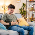 Young Man Having Stomach Pain At Home